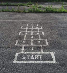 Hopscotch game on asphalt | "Getting Started" by Dr Carlos Garcia | Anxiety & Depression Counseling Blog | Tampa Counseling and Wellness | 2 Locations: Land O' Lakes, FL 34638 & Tampa, FL 33618